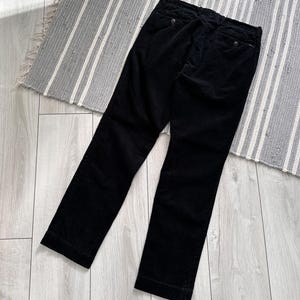 Puede incluir: Pantal&oacute;n de pana negro de pierna recta.