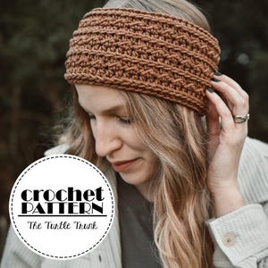 May include: A brown crochet headband with a textured stitch pattern. The headband is wide and covers the forehead. The image includes the text "crochet PATTERN" and "The Turtle Trunk" in a circular design.