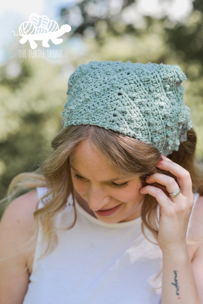 Puede incluir: Una mujer lleva una diadema de crochet verde claro con un patr&oacute;n texturizado. La diadema est&aacute; atada en la parte posterior de su cabeza. Lleva un top blanco sin mangas y tiene un tatuaje en la mu&ntilde;eca que dice "imagine".