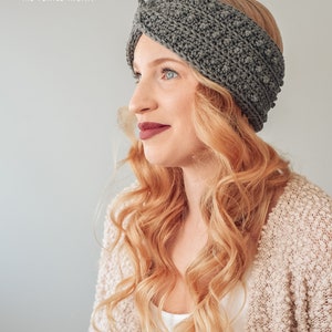 May include: A gray crocheted headband with a twisted design. The headband is worn by a person with long, blonde hair.