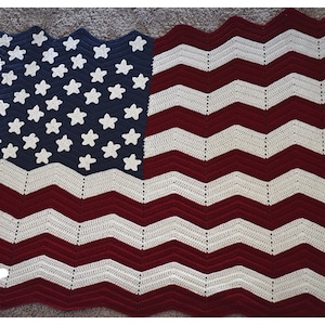 May include: A crocheted American flag blanket in red, white, and blue. The stars are white on a blue background, and the stripes are red and white.