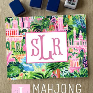 May include: A colorful Mahjong card sticker with a tropical design, featuring a pink monogram and the text "MAHJONG Card Sticker." Four Mahjong tiles are placed above the card. The sticker has a vibrant floral and architectural pattern.