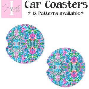 May include: Two car coasters with a vibrant floral pattern in shades of blue, pink, and green. The coasters have a circular shape with a small notch on one side. Text on the image reads "Car Coasters" and "* 12 Patterns available *."