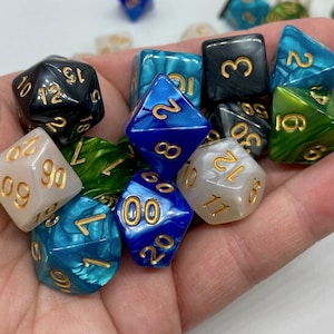 Puede incluir: Un conjunto de diez dados con diferentes colores y patrones. Los dados están hechos de un material translúcido con números dorados. Los colores incluyen azul, verde, blanco y negro.