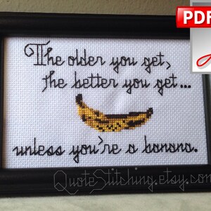 Puede incluir: Arte de punto de cruz enmarcado en negro con el texto: "Cuanto mayor te haces, mejor te pones... a menos que seas un plátano". Un plátano bordado está debajo del texto. El nombre de la tienda Etsy está en la parte inferior.