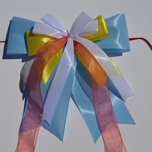 Peut inclure: Un nœud en satin bleu avec des rubans rouges, blancs, jaunes et orange.