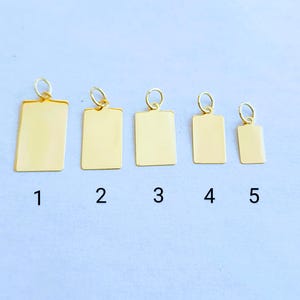 May include: Five gold-colored rectangular metal tags of different sizes with a loop at the top. The tags are numbered 1 through 5.