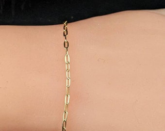 May include: A gold chain bracelet with a delicate, oval-shaped link design.