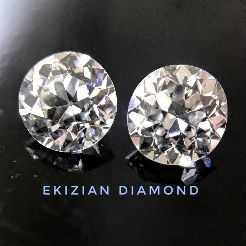 May include: Two clear round diamonds on a black background. The text "EKIZIAN DIAMOND" is printed below the diamonds.