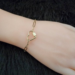 May include: A gold heart-shaped charm bracelet with a chain link design.