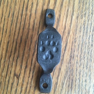 May include: Black metal door handle with a paw print design.
