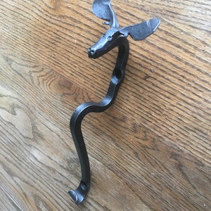 May include: Black metal moose head coat hook. The hook is shaped like a moose head with antlers and a curved body.