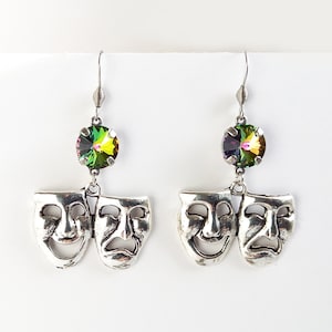 Peut inclure: Boucles d'oreilles en argent avec une paire de masques de comédie et de tragédie en argent suspendus à des pierres de cristal irisées vertes et violettes.