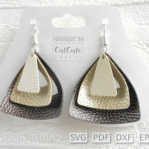 May include: A pair of layered triangle earrings with a black, gold, and white color gradient. The earrings are made of leather and have silver hooks. The text "Handmade by CutCute CRAFTS" is visible on the card behind the earrings. The text "Formats Included: SVG PDF DXF EPS" is visible at the bottom of the image.