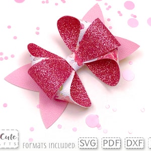 May include: A pink and white glitter bow with a floral pattern. The bow is on a white background with pink confetti.