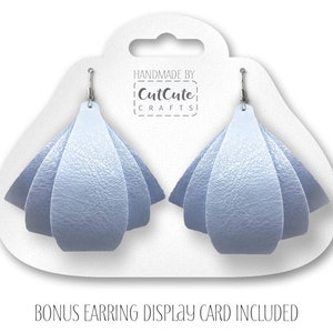 May include: A pair of light blue leather earrings with a folded design. The earrings are displayed on a white card with the text "Handmade by CutCute Crafts".