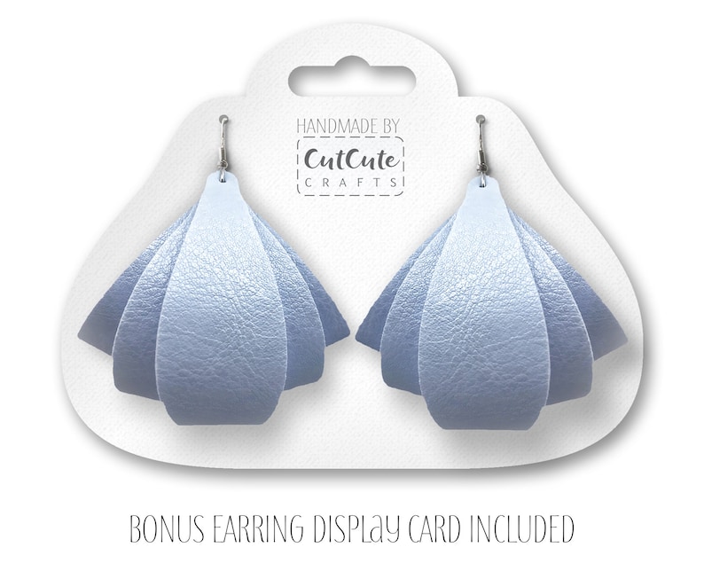 May include: A pair of light blue leather earrings with a folded design. The earrings are displayed on a white card with the text "Handmade by CutCute Crafts".