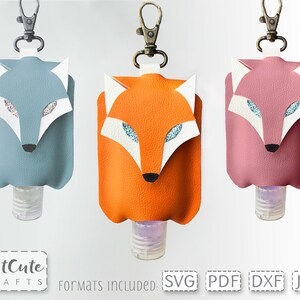 May include: Three fox-shaped hand sanitizer holders with keychains. The holders are made of faux leather and come in blue, orange, and pink. The text "Formats Included: SVG PDF DXF JPG" is at the bottom of the image.