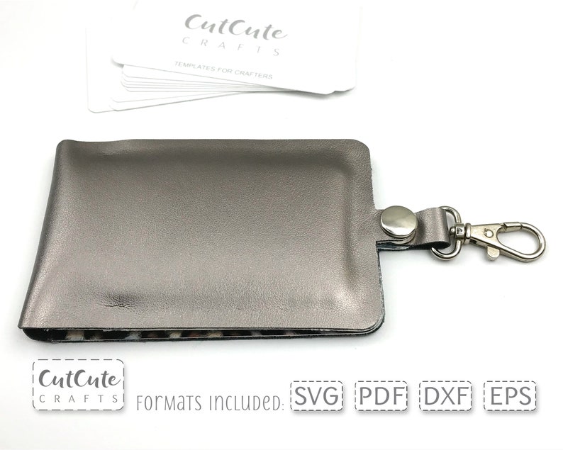 May include: A silver gray leather key chain with a metal clasp. The key chain is designed to hold a small card or ID. The image includes the text "CutCute Crafts" and "Formats Included: SVG PDF DXF EPS".