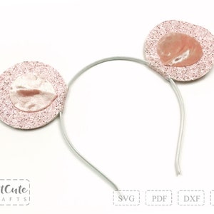 May include: Pink glitter headband with two pink velvet ears. The headband is white and the ears are attached to the headband.
