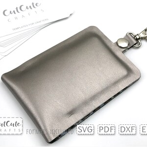 May include: A silver leather key chain with a silver metal clasp. The key chain is designed to hold a small card or other item. The text "CutCute Crafts" and "Templates for Crafters" is visible on the white card in the background. The text "SVG PDF DXF EPS" is visible on the white card in the foreground.