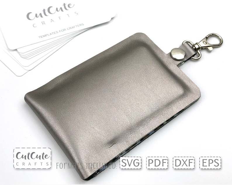 May include: A silver leather key chain with a silver metal clasp. The key chain is designed to hold a small card or other item. The text "CutCute Crafts" and "Templates for Crafters" is visible on the white card in the background. The text "SVG PDF DXF EPS" is visible on the white card in the foreground.