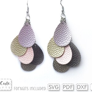 May include: A pair of dangle earrings with five layered teardrop shapes in shades of gold, pink, purple, and gray. The earrings are made of faux leather and have silver hooks.