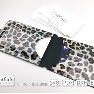 May include: A leopard print card holder with a black flap and a snap closure. The card holder is open and a credit card is visible inside. The text "CutCute CRAFTS" and "Formats INCLUDED: SVG PDF DXF EPS" is visible at the bottom of the image.