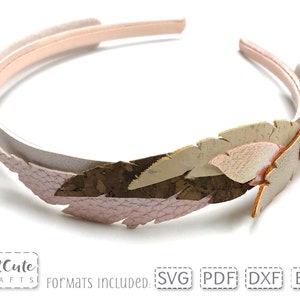 May include: A white headband with a pink and brown feather design. The feather is made of cork and faux leather.