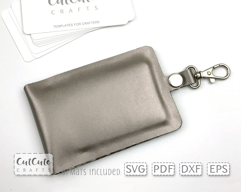 May include: A silver leather key chain with a metal clasp. The key chain is designed to hold a small card or ID. The text "CutCute Crafts" is visible in the bottom left corner of the image.