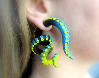 May include: A pair of black, blue, and yellow octopus-shaped ear gauges. The gauges are made of polymer clay and have a textured surface.