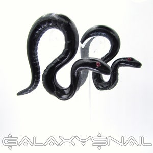 May include: A pair of black snake earrings with red eyes. The snakes are curled up in a realistic pose.