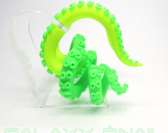May include: A bright green, plastic octopus-shaped sculpture with a curled tail and tentacles. The sculpture is on a clear acrylic stand. The text "GALAXY SNAIL" is printed in green below the sculpture.