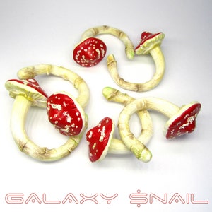 May include: Set of six red and white mushroom-shaped curtain tiebacks made of ceramic. The tiebacks are attached to wooden rings.