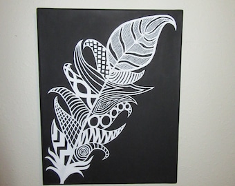 May include: A rectangular canvas wall art piece featuring a black background with a large, white, stylized feather illustration. The feather is filled with intricate, varied geometric patterns, including cross-hatching, circles, and swirls.