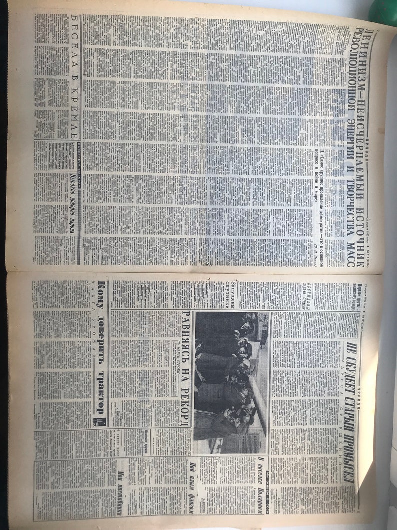 May include: A black and white newspaper page with the headline "Leninism- the inexhaustible source of revolutionary energy and creativity of the masses". The page also features a photo of a group of people in a meeting.