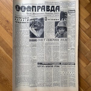 May include: A black and white newspaper with the headline "Pravda" in bold, large font. The newspaper is dated November 18, 1961. The text on the front page includes the words "Soviet Union", "Estonia", "Call to the North Field", "International Information", "Stop Barbaric Weapons", and "Preparing for Invasion".