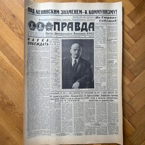 May include: A black and white newspaper with the headline "POD LENINSKIM ZNAMENEM-K KOMMUNIZMU!" and the title "PRAVDA" in bold, red letters. The newspaper is dated "22 июня 1982 года" and features a portrait of Vladimir Lenin.
