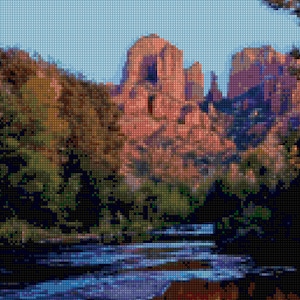 Könnte beinhalten: Eine malerische Landschaft mit einem Fluss, der durch einen Canyon fließt. Der Fluss spiegelt die roten Felswände im Hintergrund wider. Das Wasser ist leuchtend blau und die Felsen sind tiefrot.
