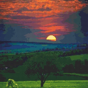 Op de afbeelding: Een levendige zonsondergang boven een veld met een enkele boom op de voorgrond. De lucht is een mix van oranje, rood en paars, met een heldere gele zon die ondergaat achter een lijn van blauwe heuvels.
