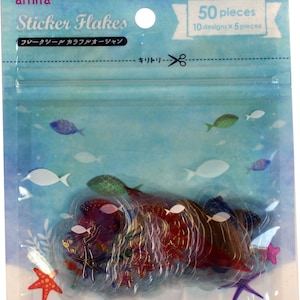 May include: A clear plastic bag filled with 50 colorful sticker flakes, featuring an ocean theme with fish, starfish, and seashells. The bag has a label that reads "amifa Sticker Flakes" and "50 pieces 10 designs x 5 pieces".