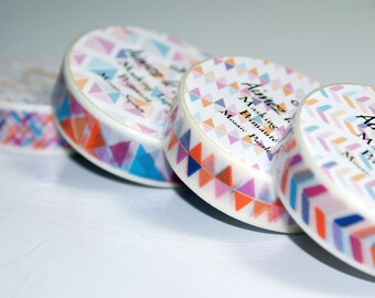 May include: Four rolls of colorful washi tape with a geometric pattern. The tape is labeled "Aimez le Tape" and "Masking Tape" with a mosaic puzzle design.