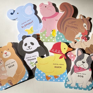 Puede incluir: Conjunto de diez blocs de notas de animales coloridos con ilustraciones de un elefante, un oso, un panda, una ardilla, un pato, un perro y un erizo. Cada bloc tiene el nombre del animal y las palabras "Animal Memo" impresas en él.