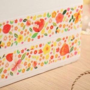 Könnte beinhalten: Zwei Streifen Washi-Tape mit einem Blumenmuster. Das Band zeigt eine Vielzahl von Blumen in den Farben Gelb, Orange, Rot und Rosa. Die Blumen sind von grünen Blättern umgeben.