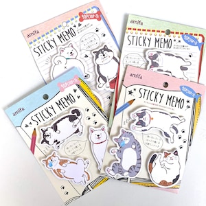 May include: Four packages of sticky notes featuring adorable cartoon animals. Each package has a different animal theme: a black and white dog, a gray cat, a brown and white cat, and a calico cat. The packages are pink, blue, and green with white text that reads "STICKY MEMO" and "90P (30P x 3)".