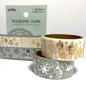May include: Three rolls of masking tape with festive Christmas designs. One roll is white with gold foil ornaments, another is grey with white gift and snowflake patterns. The packaging reads "MASKING TAPE". Width is approx. 20mm.
