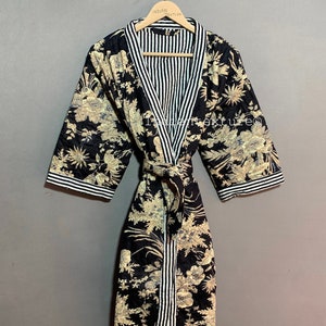 May include: A black floral print robe with a striped interior and trim. The robe features a tie closure and is displayed on a wooden hanger. The floral pattern includes beige and light blue accents.