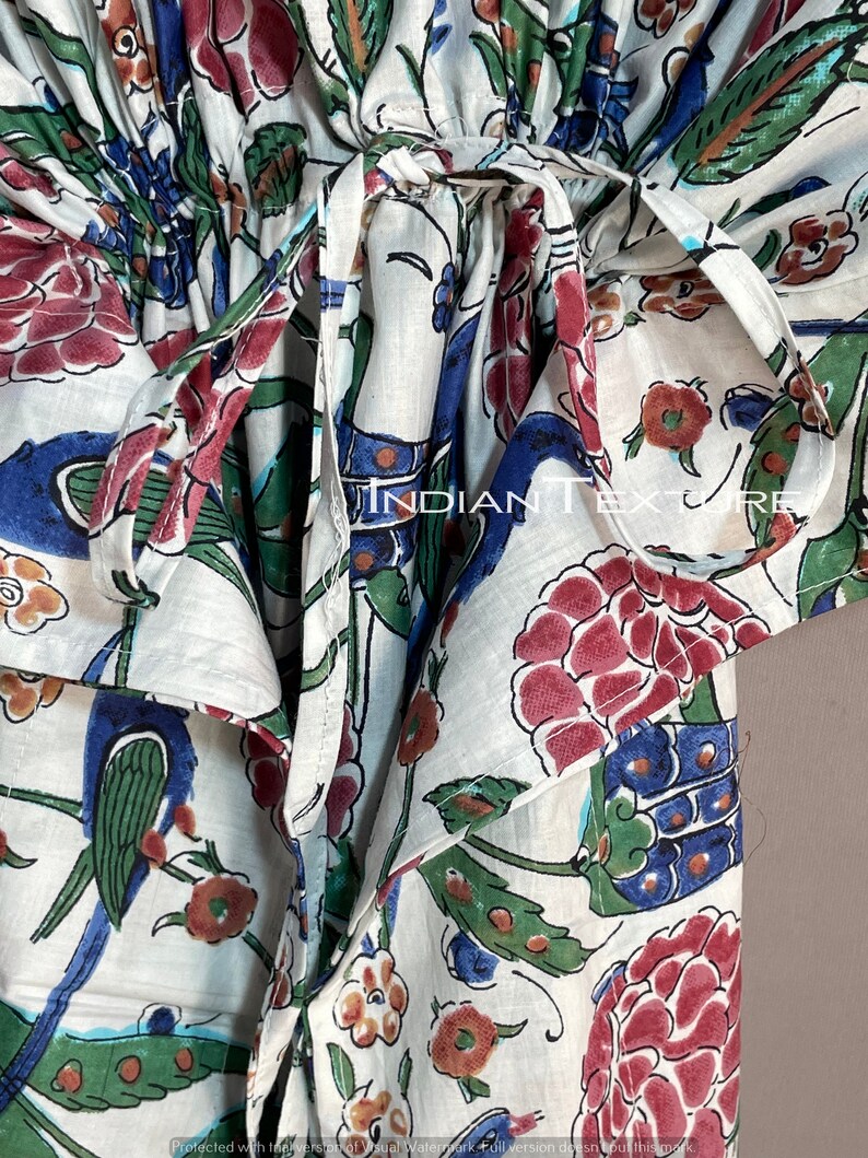 May include: White fabric garment with a floral and bird pattern in red, blue, green, and brown. The garment has a tie closure and the text "INDIAN TEXTURE" is visible.