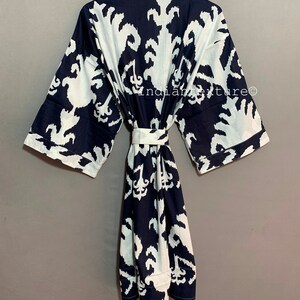 May include: A navy blue and white cotton robe with a geometric pattern. The robe has a tie belt and long sleeves.