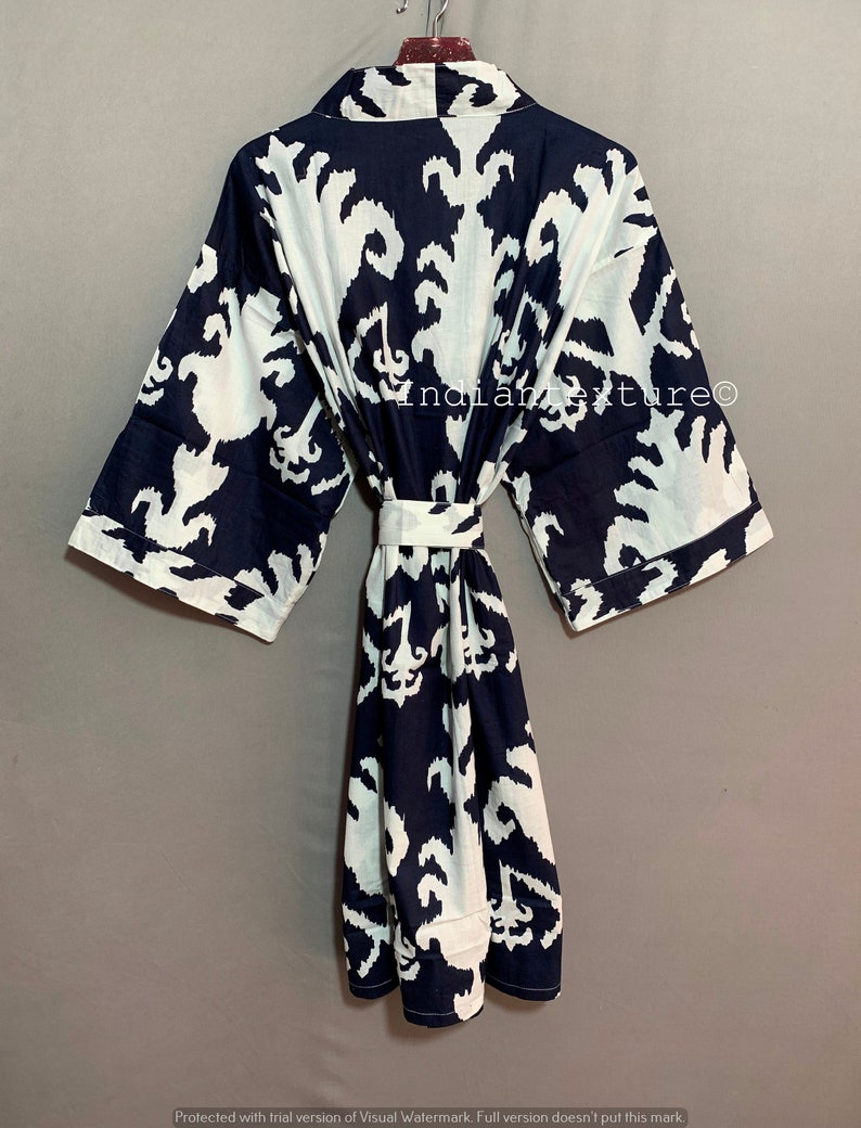 May include: A navy blue and white cotton robe with a geometric pattern. The robe has a tie belt and long sleeves.